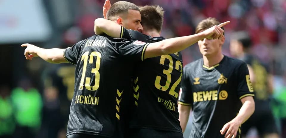Two FC Köln players celebrating a goal on field