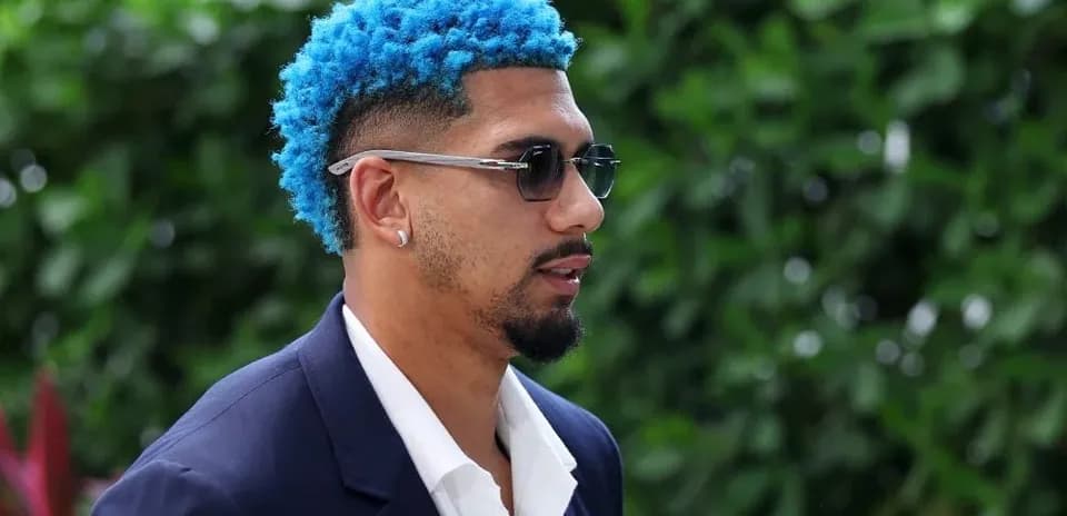 Person with blue hair wearing sunglasses outdoors