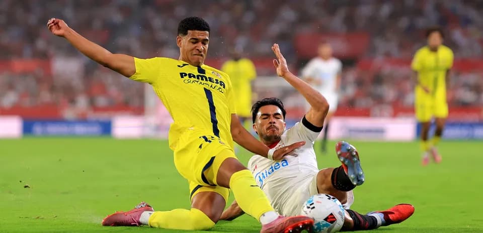 Villarreal player tackling Sevilla opponent in match