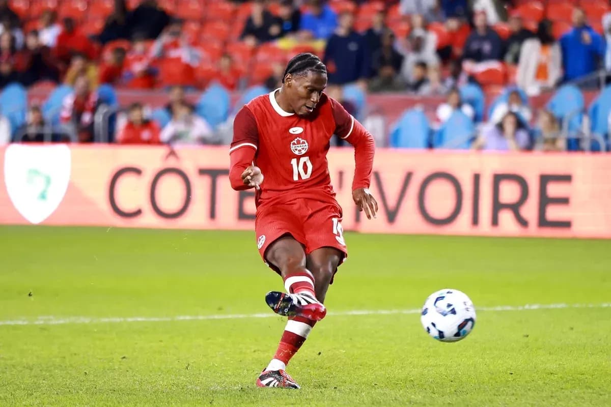 Player kicking ball during soccer match in red uniform