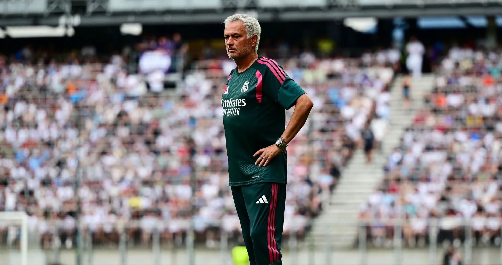 Coach observing match with crowd in background