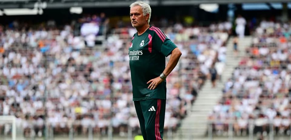Coach observing match with crowd in background