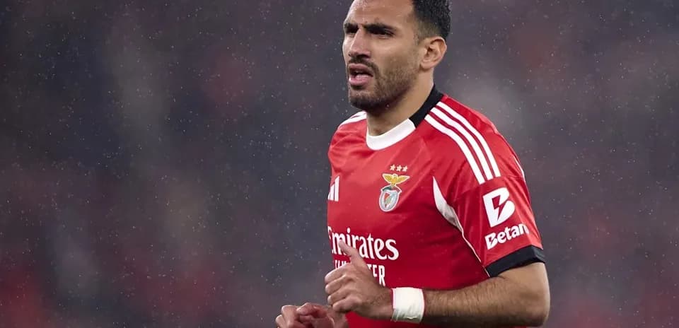 Player in red Benfica kit during rainy match