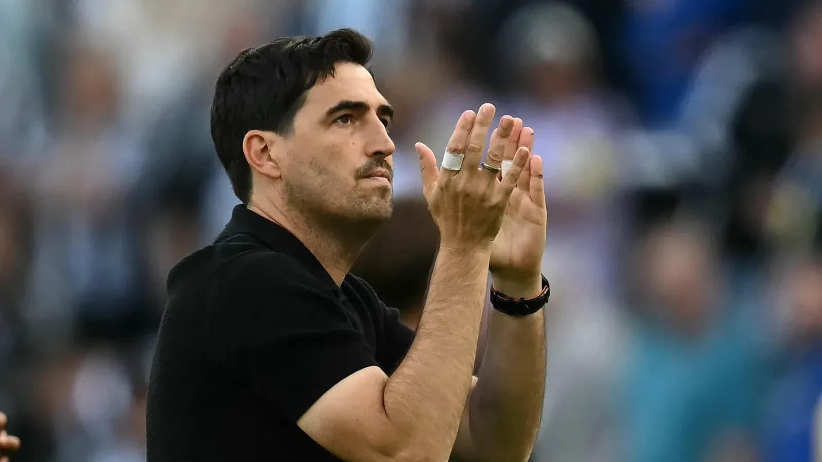 Coach applauding the crowd during a match