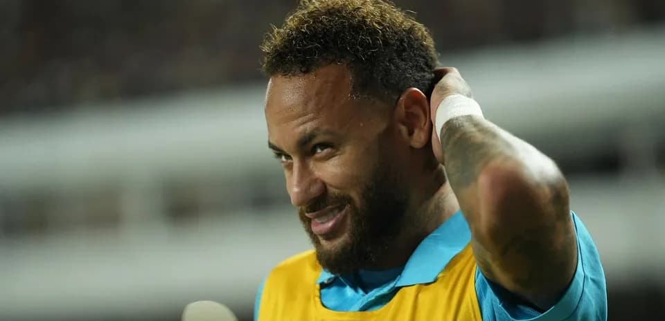 Neymar adjusting his hair on the sidelines