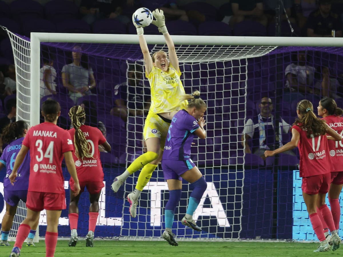Goalkeeper leaps to catch the ball during match