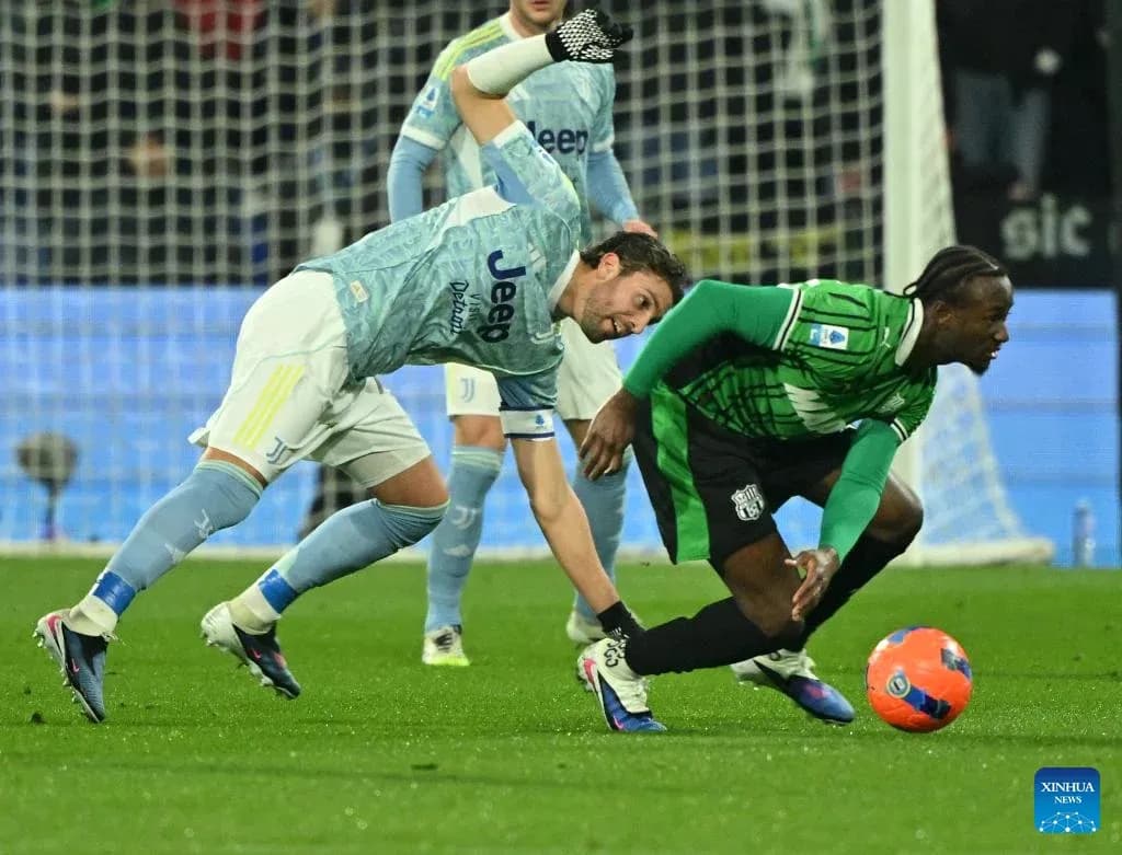 Juventus player challenges Sassuolo opponent for the ball