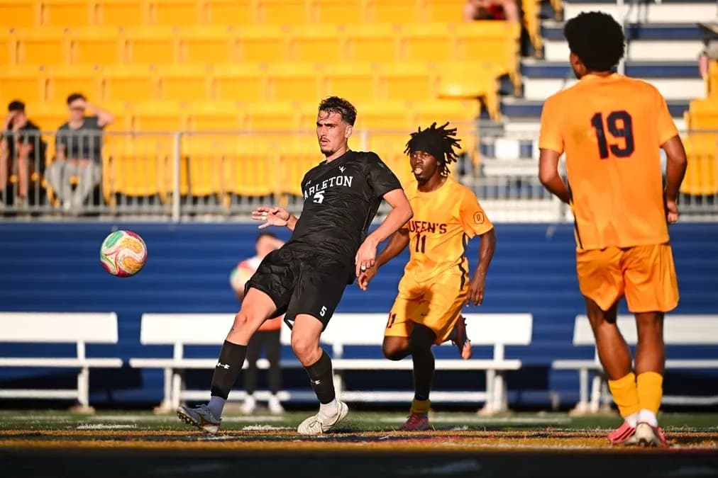 Player in black kicking ball during soccer match