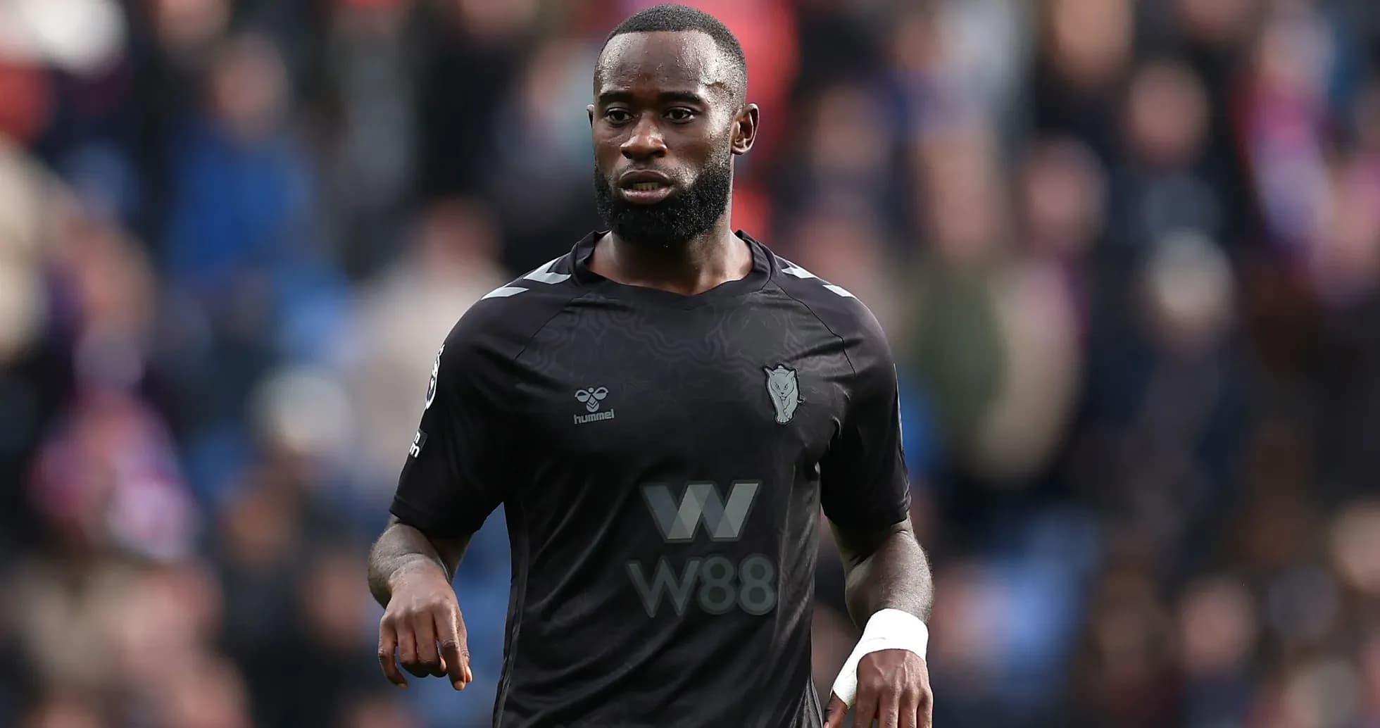 Player in black jersey walking on the pitch