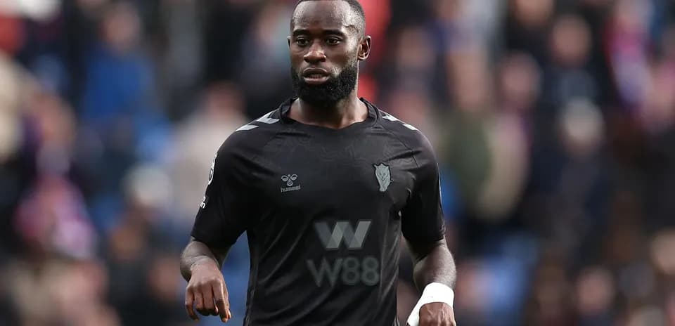Player in black jersey walking on the pitch