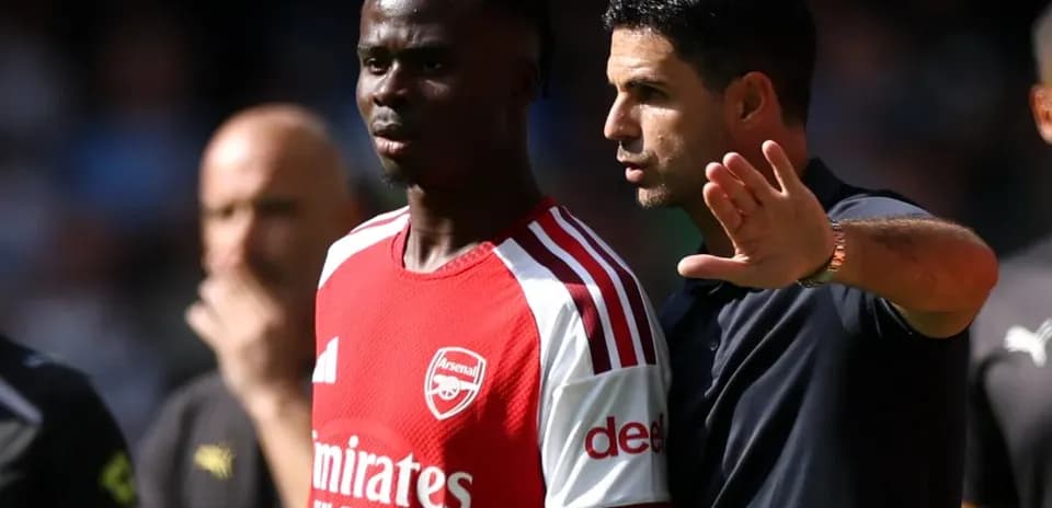 Coach discussing tactics with player on sidelines