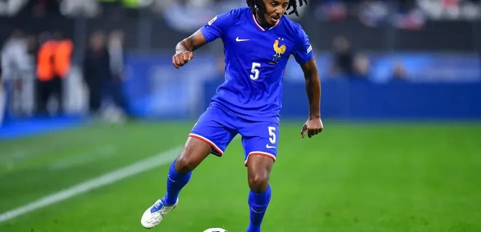 Player in blue jersey dribbling soccer ball on field