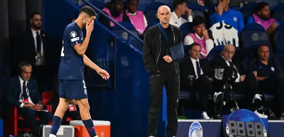 Player walking off field with coach observing