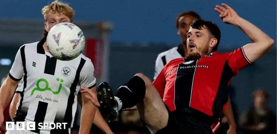 Player in red shirt falling while contesting ball