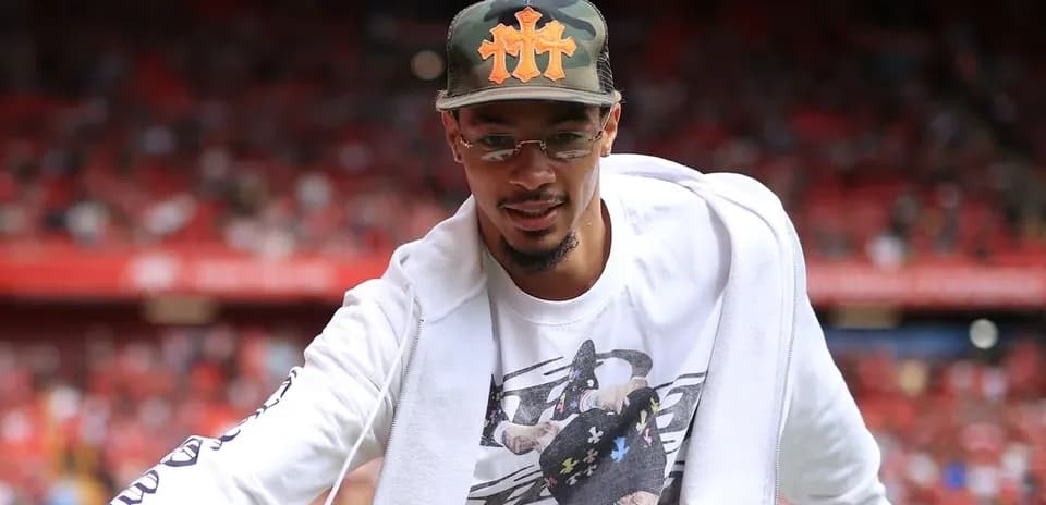 Man in cap greeting crowd at sports venue
