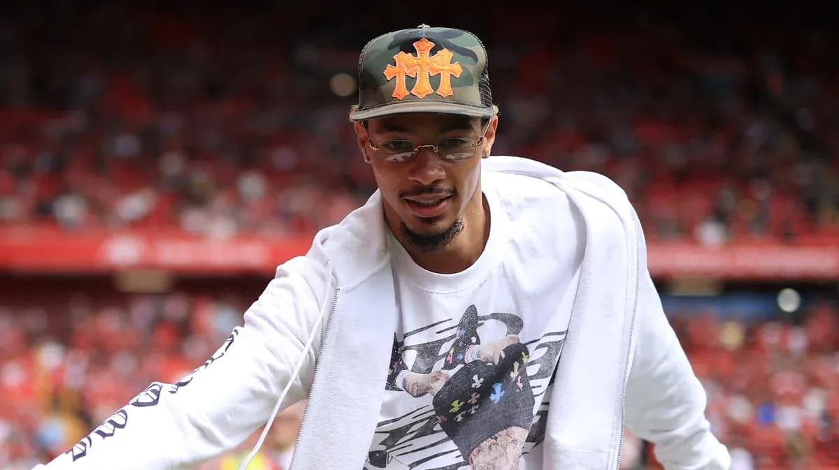 Man in cap greeting crowd at sports venue