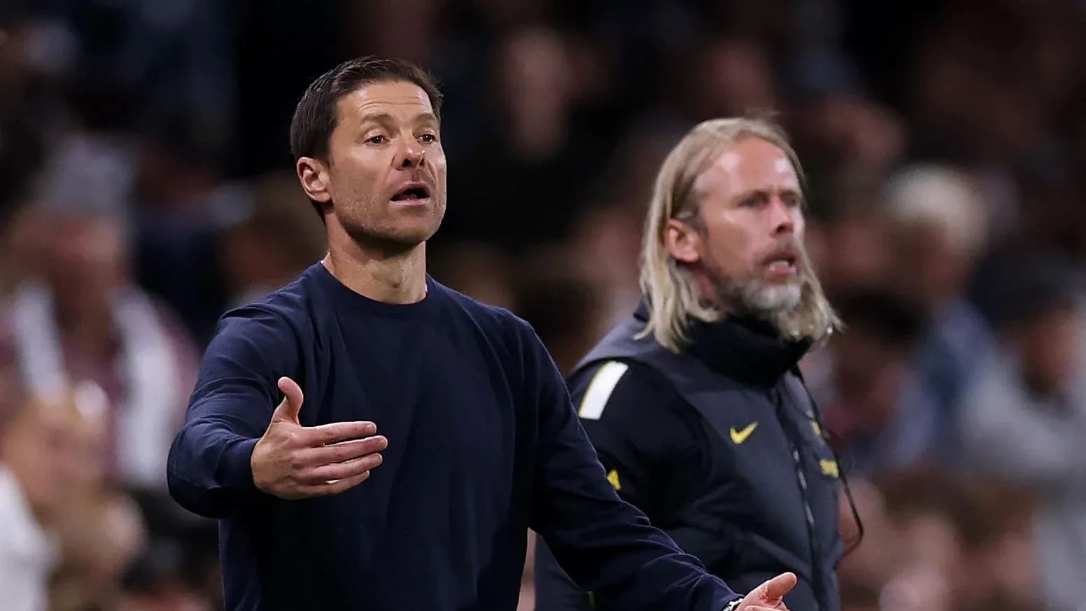 Coaches gesturing during a match on the sidelines