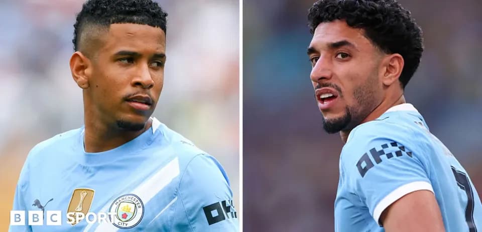Two Manchester City players in light blue jerseys
