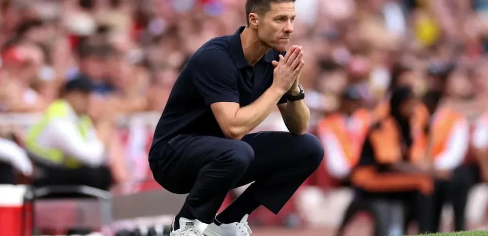 Coach observing the match while kneeling on sidelines