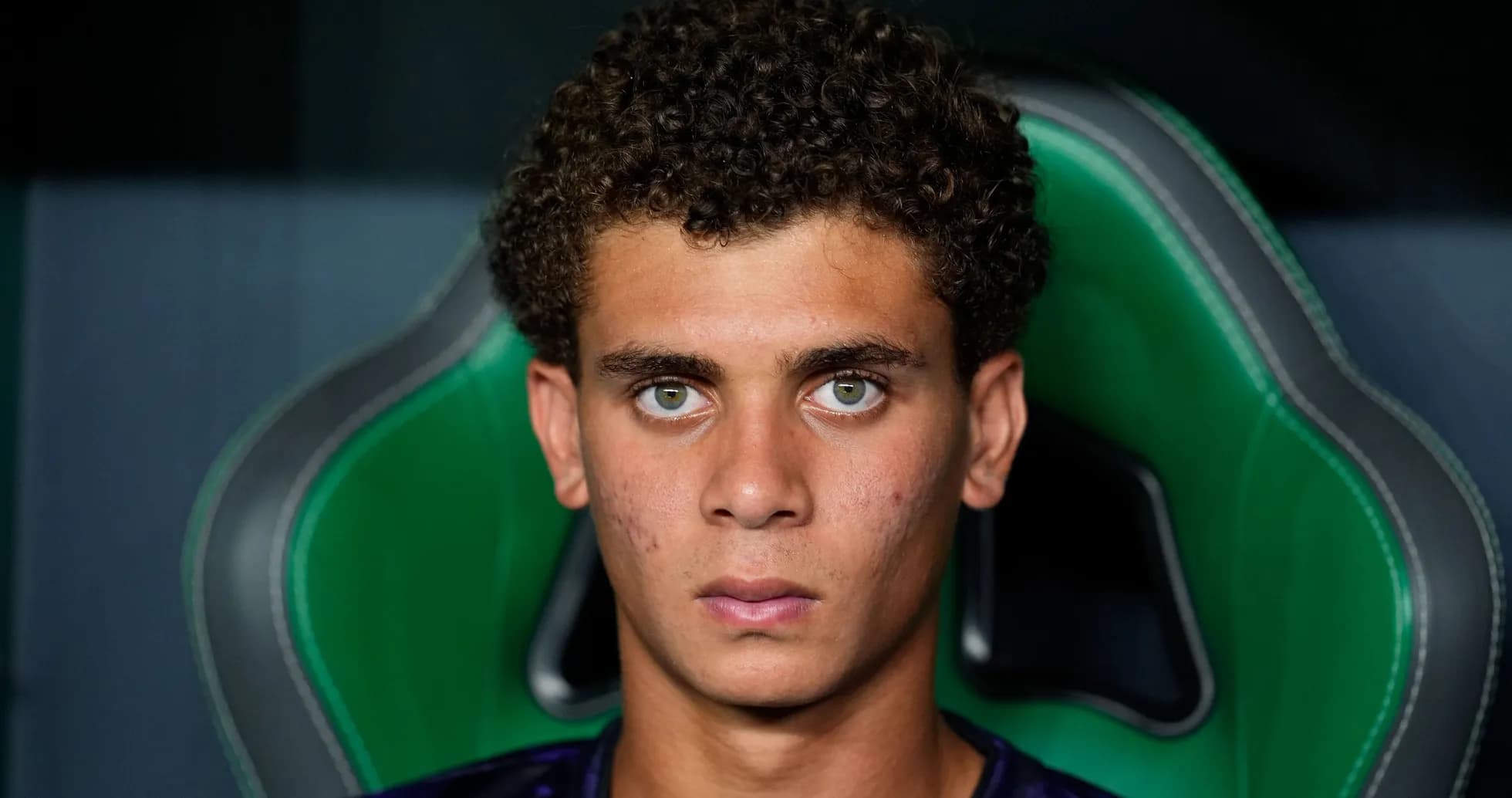 Young athlete seated in sports chair, serious expression