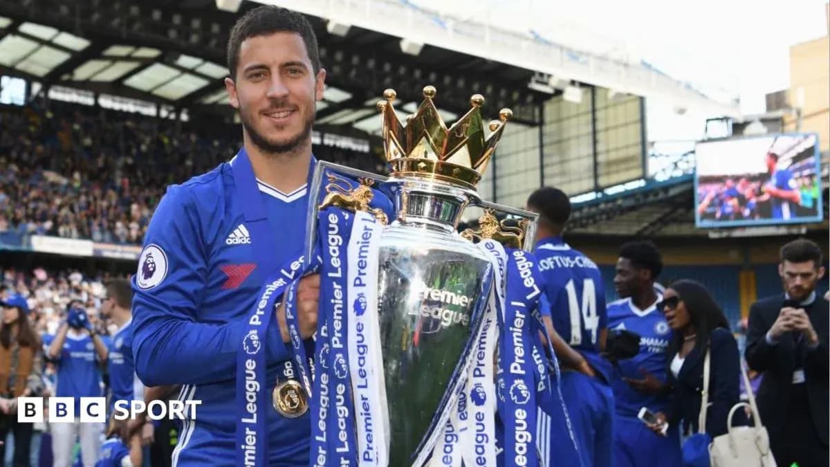 Player holding Premier League trophy on pitch