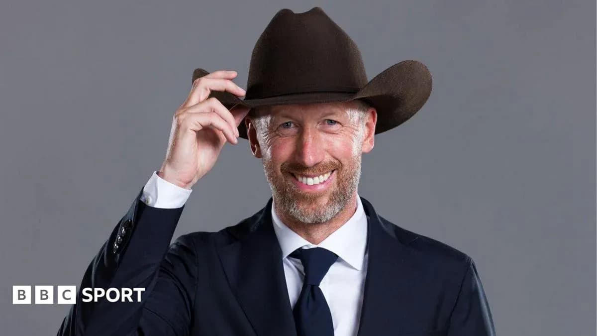 Man in suit and cowboy hat smiling at camera