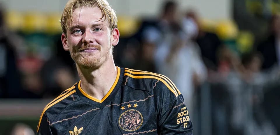 Player smiling in Ajax jersey after match