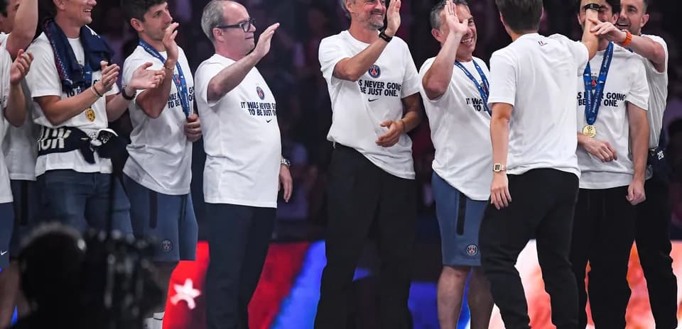 Team celebrating on stage after a victory