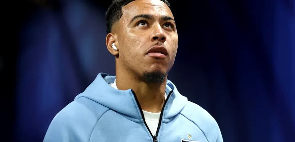 Player wearing England hoodie with earbuds, looking up