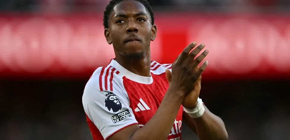 Player clapping in Arsenal jersey at stadium