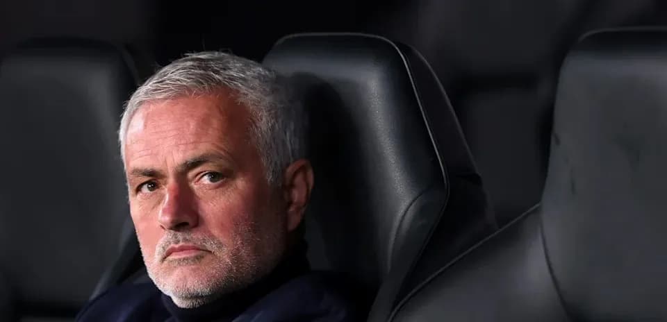 Manager seated on bench during a match