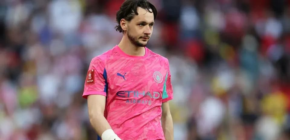 Goalkeeper wearing pink kit walking off the pitch