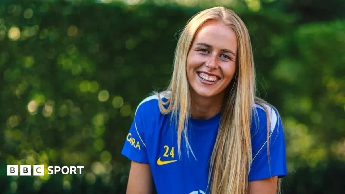 Female football player smiling in training kit