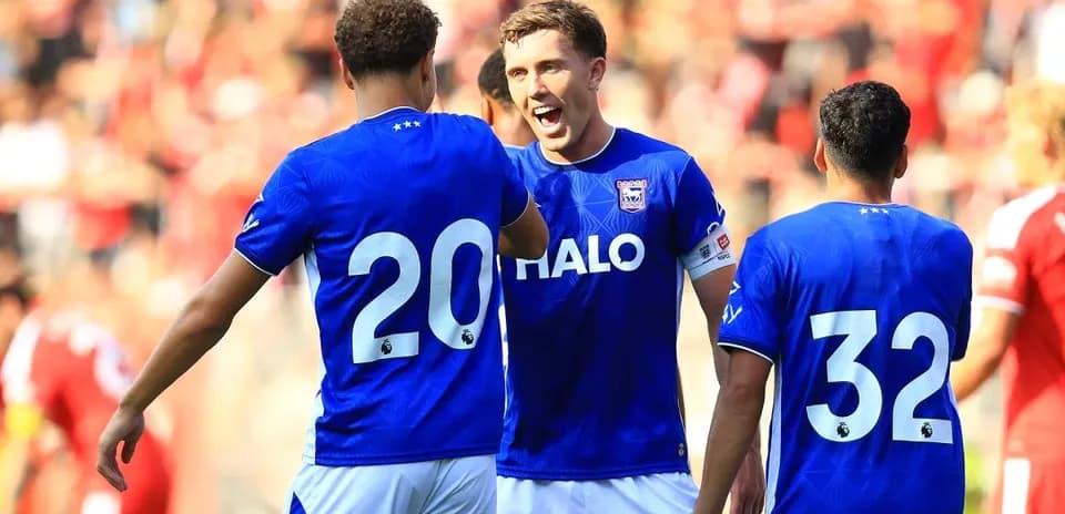 Three players celebrating in blue team jerseys