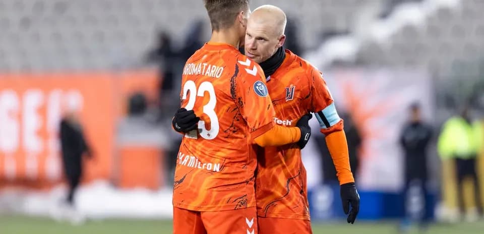 Players celebrating after match in orange jerseys