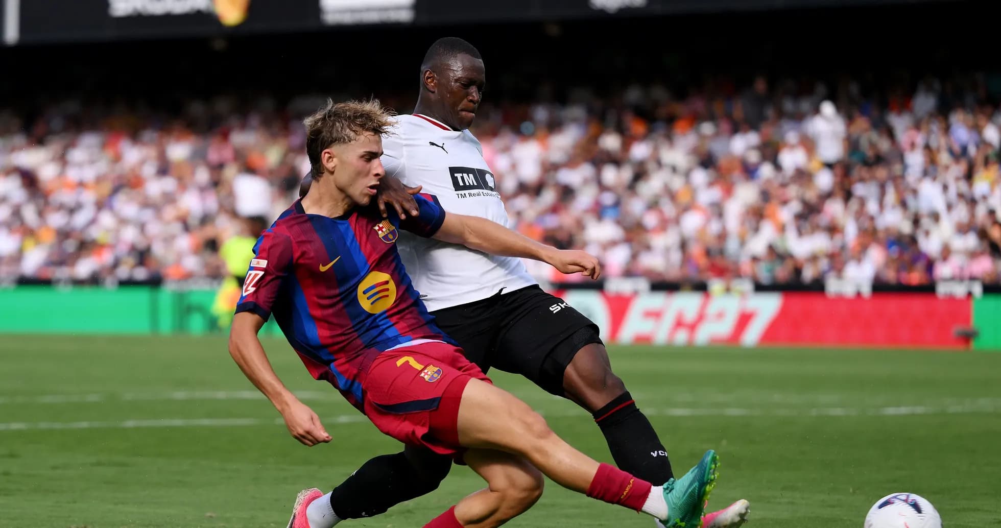 Player from Barcelona tackling opponent during match
