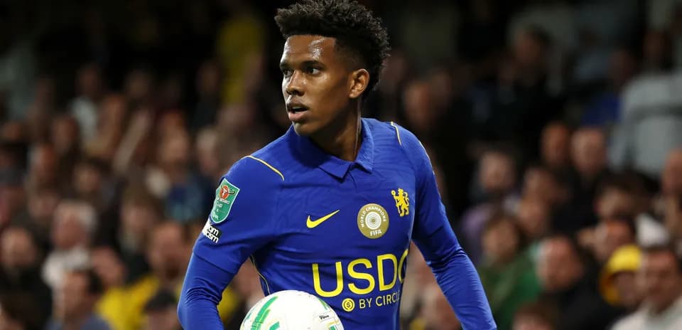 Player in blue kit holding soccer ball during match