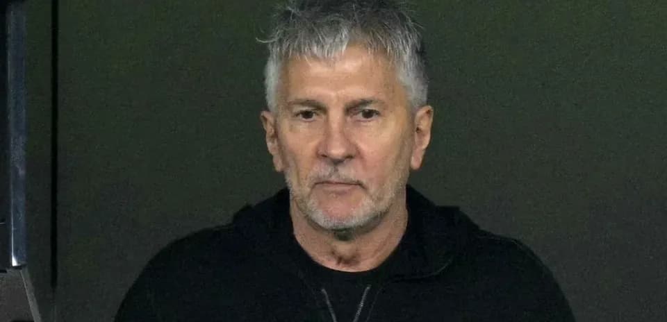 Man in black hoodie looking intently at scene