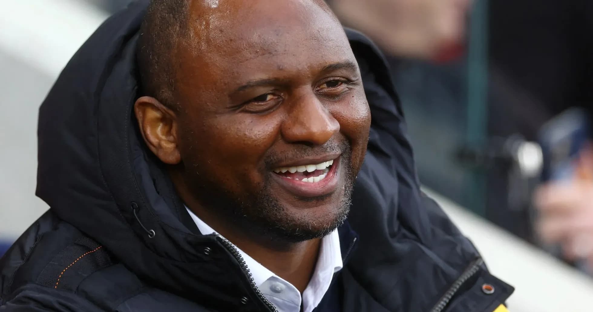 Man smiling while seated in a sports venue