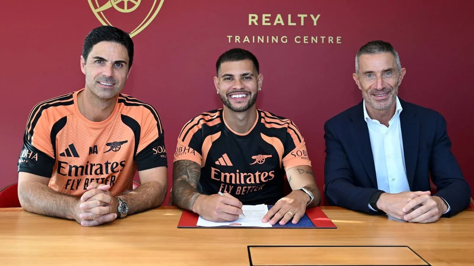 Player signing contract with club officials at table