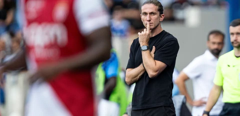 Coach observing match with finger to lips