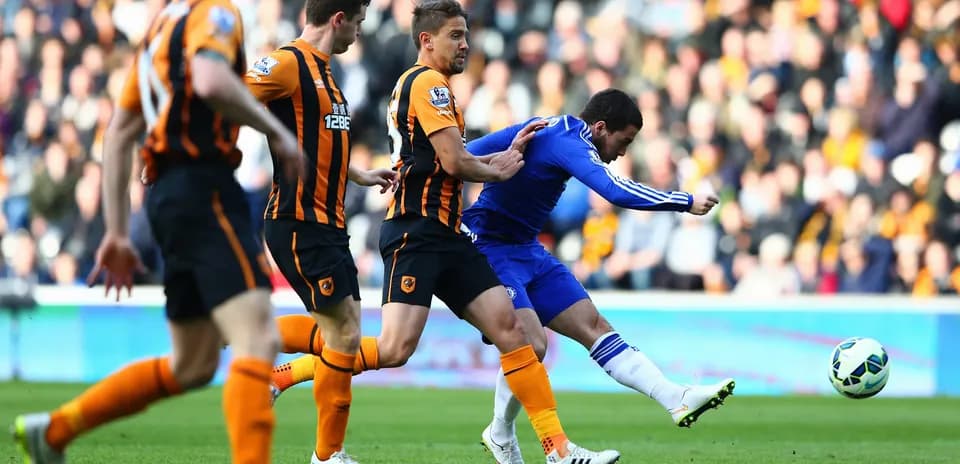 Chelsea player shooting against Hull City defenders