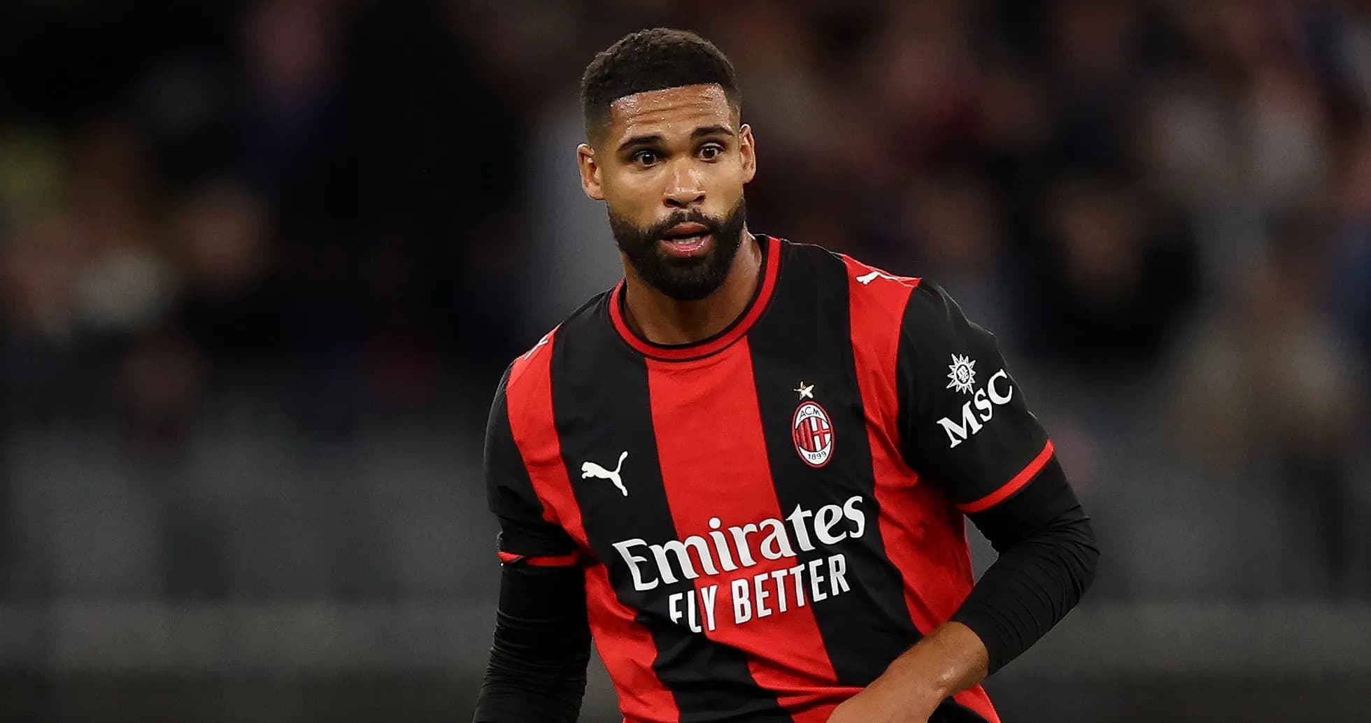 Player in AC Milan jersey during match action