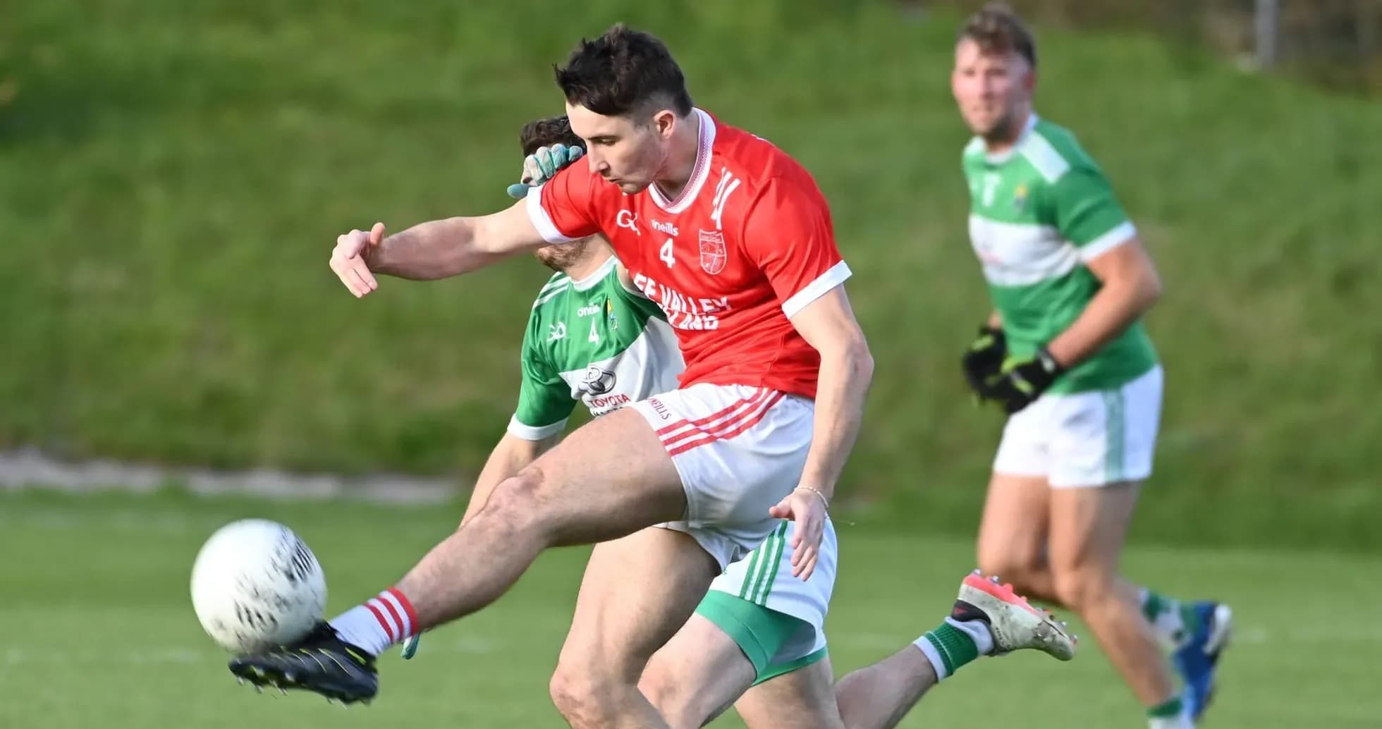 Player kicking a ball during a Gaelic football match
