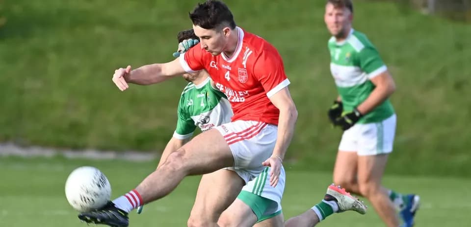 Player kicking a ball during a Gaelic football match
