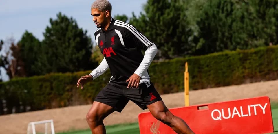 Player training on the pitch wearing Liverpool gear
