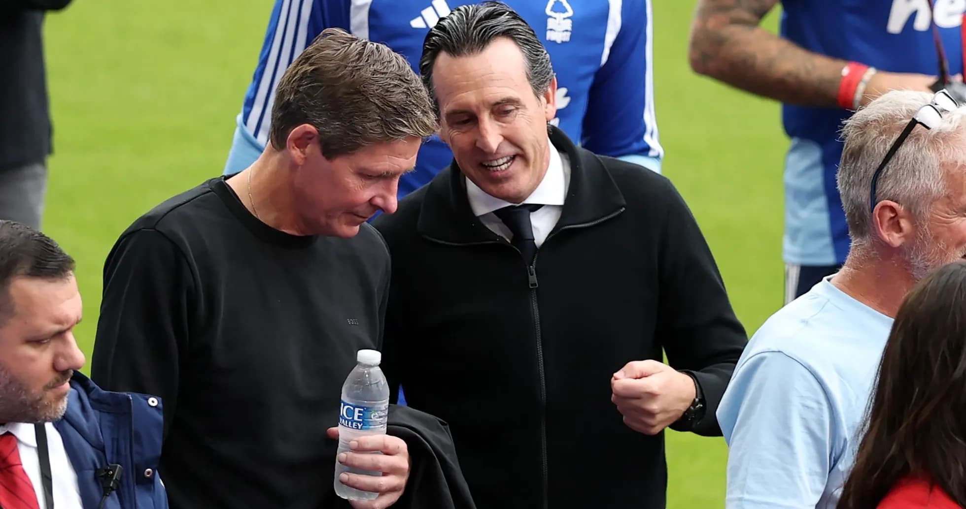 Two men talking on the pitch before a match