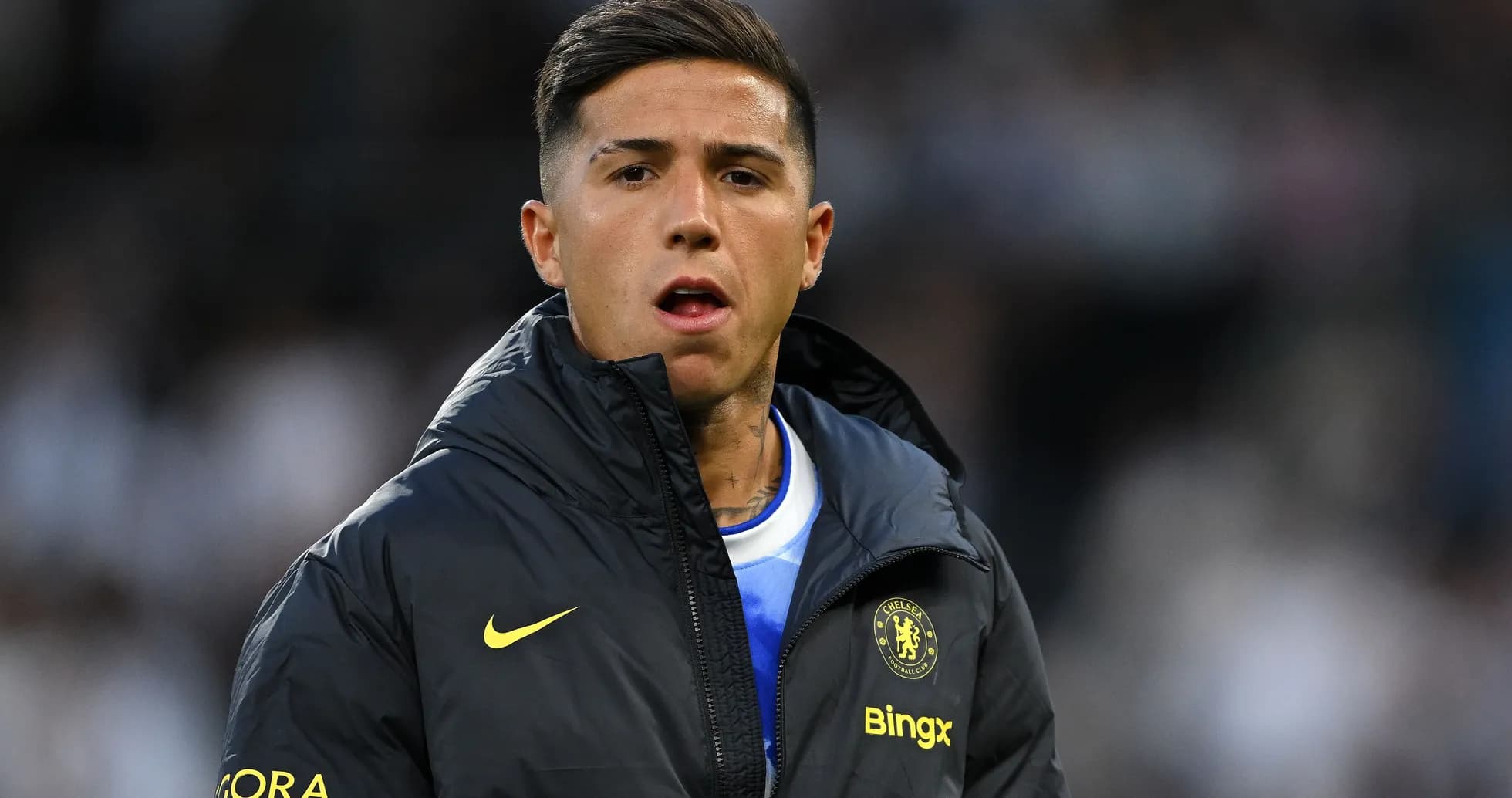 Player in Chelsea jacket on sidelines during match