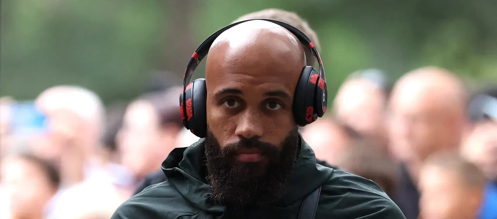 Player wearing headphones walking through crowd