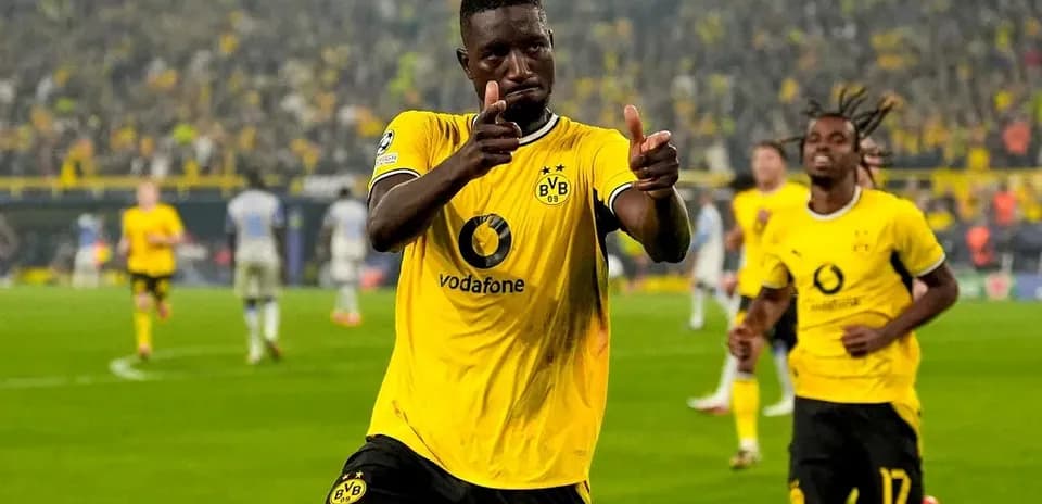 Player celebrating a goal with teammates in stadium